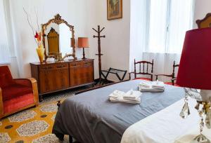 een slaapkamer met een bed, een dressoir en een spiegel bij [La casa dell'Arte] con parcheggio gratuito in Genua