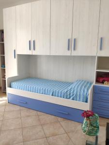 uma cama num quarto com armários brancos em Sul mare con spiaggetta privata vicino a Cefalù. em Buonfornello