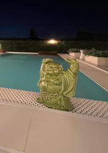 una statua seduta di notte accanto alla piscina di Palazzo Firenze a Napoli