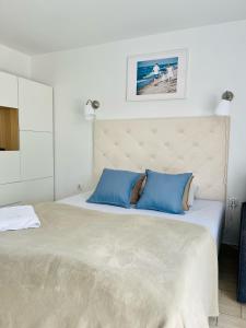 a bedroom with a large bed with blue pillows at Pokoje Gościnne i Apartamenty Ula in Ustronie Morskie