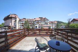 a patio with a table and chairs on a balcony at Apartament Patrick in Gura Humorului