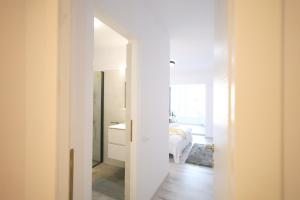 Baño blanco con cama y espejo en Apartament Patrick, en Gura Humorului