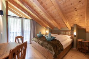 um quarto com uma cama grande e um tecto de madeira em Enzianhütte em San Giuseppe in Anterselva