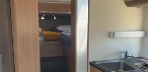 a kitchen with a sink and a room with a bed at Camper Relax in Murter Slanica beach - with clima in Tisno