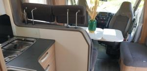 a small kitchen in an rv with a table at Camper Relax in Murter Slanica beach - with clima in Tisno +32 photos