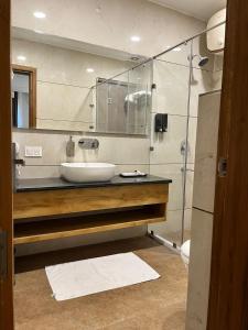 La salle de bains est pourvue d'un lavabo et d'une douche. dans l'établissement Hotel Tamarind Tree, à Kharar