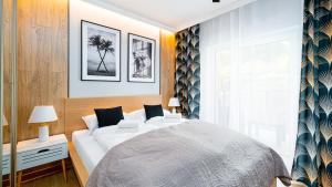 sypialnia z dużym białym łóżkiem i oknem w obiekcie Apartamenty Sun & Snow Osada w Szklarskiej Porębie