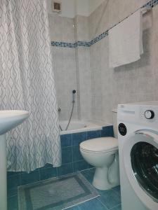 a bathroom with a toilet and a washing machine at GnA Place in Zakynthos Town
