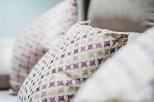 almohada rosa y blanca sentada en una cama en Apartamento Centro Granada, en Granada