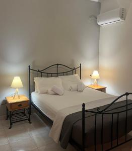 a bedroom with a large bed with two lamps at Panorama Thea in Symi