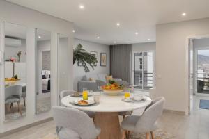 une salle à manger et un salon avec une table et des chaises dans l'établissement Barreiros III by An Island Apart, à Funchal 13 autres photos