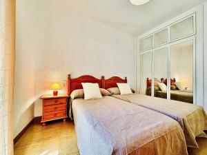 1 dormitorio con cama, tocador y espejo en Viamar Apartament, Costabravasi, en Santa Cristina d'Aro