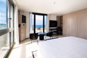 a bedroom with a bed and a table and chairs at L'Agapa Hôtel - Spa Codage in Perros-Guirec