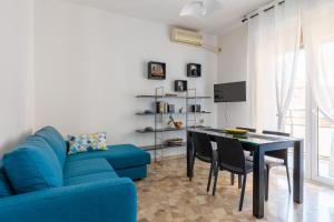 ein Wohnzimmer mit einem blauen Sofa und einem Tisch in der Unterkunft Appartamento Ibisco by Wonderful Italy in Bologna