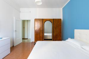 ein Schlafzimmer mit einem weißen Bett und einer Holztür in der Unterkunft Appartamento Ibisco by Wonderful Italy in Bologna