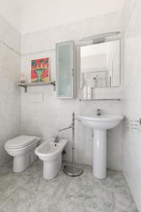 ein weißes Bad mit einem WC und einem Waschbecken in der Unterkunft Appartamento Ibisco by Wonderful Italy in Bologna
