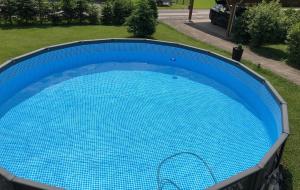 una gran piscina azul en el césped en Haus Söding, en Soding