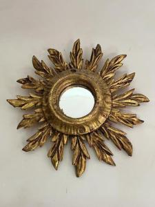 a gold sunburst mirror on a white background at Iconic Italian Townhouse w Rooftop Terrace, Pigna in Pigna