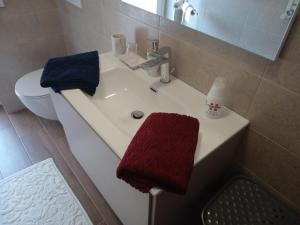 新喬瓦尼提蒂諾的住宿－Dolce Casa，浴室设有水槽和红色及蓝色毛巾。