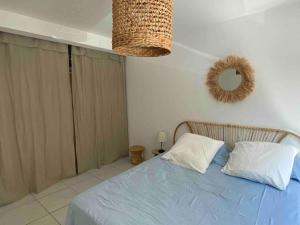 a bedroom with a blue bed and a mirror at Cocon les pieds dans l'eau Accès direct à la mer in La Ciotat