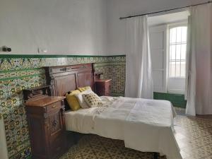 um quarto com uma cama grande e uma cabeceira em madeira em casa señorial Sara em Trigueros