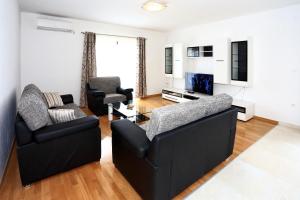 ein Wohnzimmer mit 2 Sofas und einem TV in der Unterkunft Apartment Ante in Bibinje