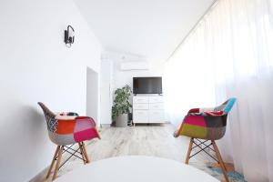 a living room with two chairs and a tv at Apartament Patrick in Gura Humorului