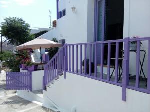 a purple railing on a balcony with an umbrella at Vourkari Studio 2 with kitchen in Ioulis