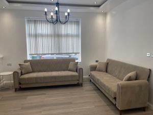 una sala de estar con 2 sofás y una lámpara de araña. en Araan House Hotel -Families and Couples Only en Blackpool