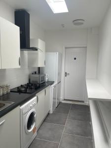 a kitchen with a washing machine and a washer at Araan House Hotel -Families and Couples Only in Blackpool