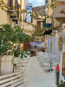 une rangée de tables et de chaises dans une ruelle dans l'établissement Le Plejadi, à Castellammare del Golfo