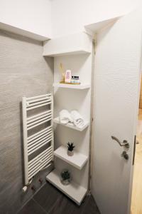 Un baño con estantes blancos y ducha. en Apartament Patrick, en Gura Humorului