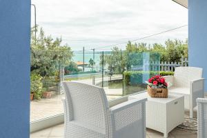 Un balcón con sillas y una mesa con una cesta de flores. en Maranto Terra - YourPlace Abruzzo, en Fossacesia