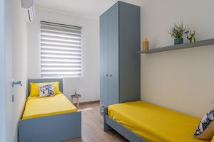 Cette petite chambre comprend un lit jaune et une armoire. dans l'établissement Maranto Vista - YourPlace Abruzzo, à Fossacesia