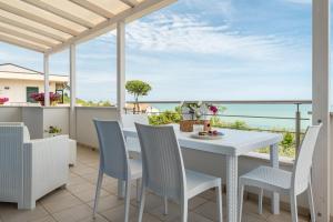 - une table et des chaises blanches sur un balcon donnant sur l'océan dans l'établissement Maranto Vista - YourPlace Abruzzo, à Fossacesia