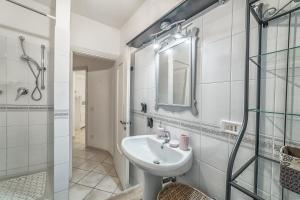 een witte badkamer met een wastafel en een douche bij Sunshine House - Ostuni BB di Antonella in Ceglie Messapica +35 foto's