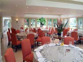 a dining room with tables and red chairs at The Old Vicarage in Bridgnorth