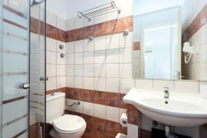 a bathroom with a toilet sink and a mirror at Balaris Apartments in Kassiopi