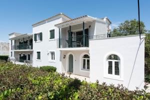 a white house on top of a hill at Balaris Apartments in Kassiopi