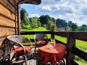 a table and chairs on a porch with a view at Przytulia willa in Stryszawa