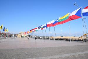 a row of flags on poles in a square at Dune Hotel Nieuwpoort in Nieuwpoort