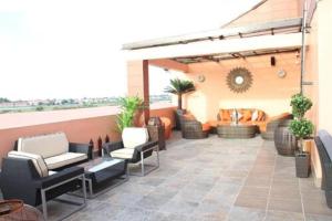an outdoor patio with chairs and a couch at Palazzo Dumont Hotel in Ikota