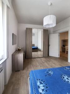1 dormitorio con cama azul y espejo en Incantevole Appartamento Genova Quinto vicino alla spiaggia en Génova