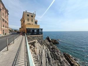 un edificio en un acantilado junto al océano en Incantevole Appartamento Genova Quinto vicino alla spiaggia en Génova