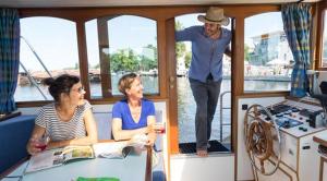 two women and a man standing on a boat at KUHNLE-TOURS Kabinen in Rechlin