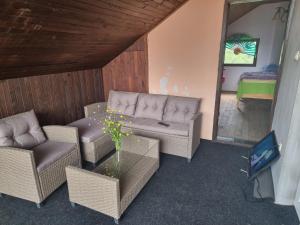 sala de estar con muebles de mimbre y TV en Guest house Sistem en Brčko