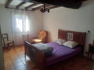 una camera da letto con un letto e una sedia di Maison de charme à Arnaud-Guilhem avec vue sur la montagne a Arnaud-Guilhem