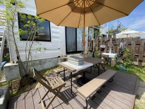 a patio with an umbrella and a table and chairs at 天草VIVID V1 in Kami Amakusa