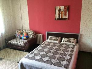 um quarto com uma cama e uma cadeira em ЛЮКС на Юго-востоке,Степной1 em Karaganda