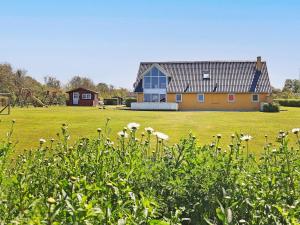a house in a field of grass with flowers at 10 person holiday home in Vinderup in Vinderup